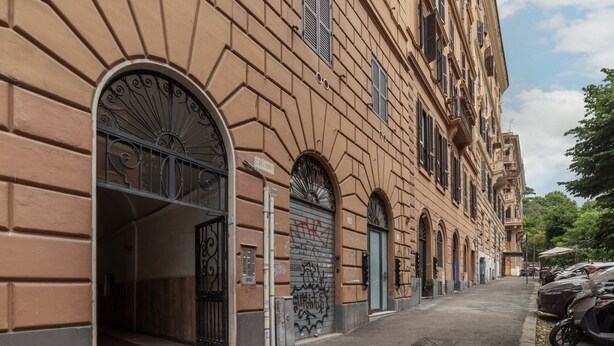 A building with arched windows and a gated entrance. - GuestHost - Trastevere Three Luxury Rooms (Roma)