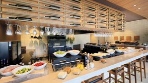 A modern kitchen with a long counter, various cooking appliances, and hanging utensils. - BLISSTIA Hakone Sengokuhara (Hakone)