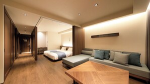 A modern hotel room with a wooden floor, a sofa, a bed, and a wooden coffee table. - BLISSTIA Hakone Sengokuhara (Hakone)