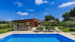 A swimming pool with lounge chairs and a bar area. - Villa Paliska by Interhome (Poreč)