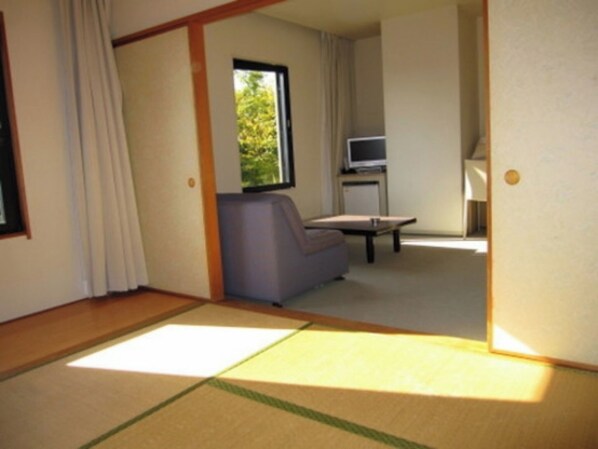 A room with a sofa, a television on a stand, and a window with curtains. - Nonsmoking Japanesestyle room type A Simple Sta / Maebashi Gunma (Maebashi)