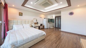 A bedroom with a bed, a bedside table, a mirror, and a wall-mounted clock. - Namhae Ryu&lee Pet Pension (Namhae)