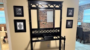A black console table with a mirror, surrounded by framed pictures on the wall. - Cozy 1-bedroom apartment with WiFi, AC in wonderful Baton Rouge (Baton Rouge)