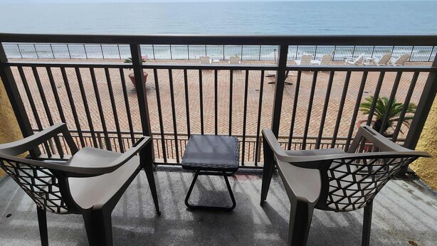 A balcony with a view of the beach, featuring a table and two chairs. - Caravelle 841 (Myrtle Beach)