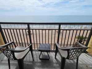 A balcony with a view of the beach, featuring a table and two chairs. - Caravelle 841 (Myrtle Beach)