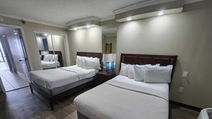 A hotel room with two beds, a mirror, a nightstand, and a lamp. - Caravelle 841 (Myrtle Beach)