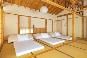 Ein traditioneller japanischer Raum mit Tatami-Böden, Holzbalken und einem Shoji-Bildschirm.