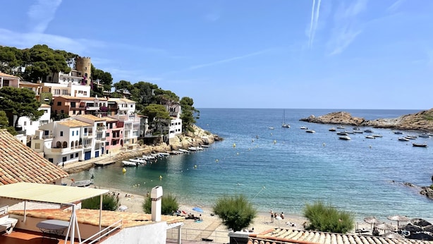 A coastal town with buildings along the water, boats, and a clear sky. - Sa Tuna - House with Views and 30m from the Sea (Begur)