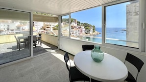 A balcony with a table and chairs, overlooking a coastal town and the sea. - Sa Tuna - House with Views and 30m from the Sea (Begur)