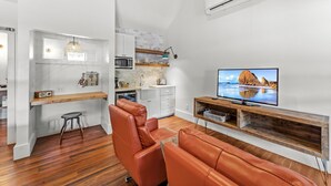 Een moderne woonkamer met een leren bank, een flatscreen televisie en een houten tv-meubel.