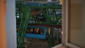 A cable car system with a blue car, green metal structure, and a building with the number 3 in the background. - Chic and Spacious 2Room Apartment in Wuppertal Center with Free WiFi and Kitchen (Wuppertal)