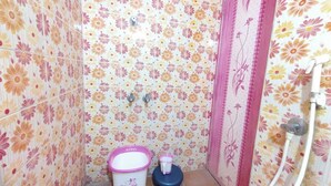 A bathroom with floral wallpaper, a toilet, a bidet, and a shower. - Feel at Home: Exceptional Comfort and Convenience! (Chennai)