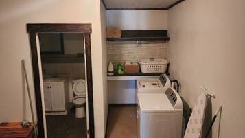 A laundry room with a washing machine, a dryer, and a folding table.