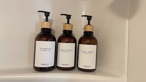 Three bottles of body wash, conditioner, and shampoo on a shelf.