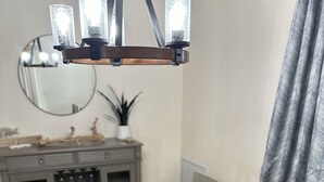 Uma mesa de jantar com jogos americanos trançados e uma bandeja de madeira com objetos decorativos.
