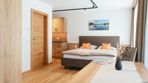 A bedroom with a bed, bedside table, and a painting on the wall. - Moderne Ferienwohnung (Großarl)