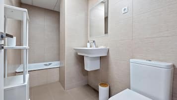 A modern bathroom with a toilet, sink, and shower.