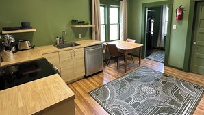 Une cuisine compacte équipée d’un lave-vaisselle, d’un évier et d’un coin repas avec une table et des chaises.