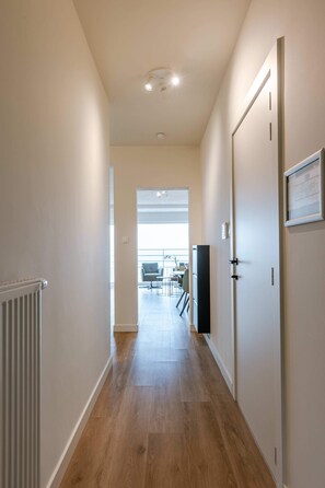 Stunning hallway leading to a spacious room with a large window and a dining area.