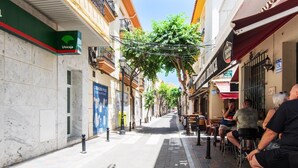 A narrow street with outdoor seating, a café, and a dog. - Cozy Apartment on the Beach, ideal for couples (FUENGIROLA)