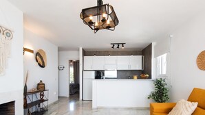 A modern living room with a sofa, a coffee table, and a kitchen in the background. - Coral Island, Mediterranean Duplex Penthouse (BENALMADENA COSTA)