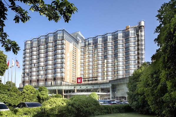 A multi-story hotel with a modern design, featuring a glass facade and a prominent entrance. - Grand Millennium Shanghai Hongqiao (Shanghai)