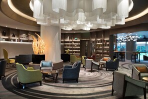 A modern lobby with a central seating area, bookshelves, and a large decorative sculpture. - Grand Millennium Shanghai Hongqiao (Shanghai)