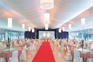 A banquet hall with a red carpet, round tables, and chairs. - Grand Millennium Shanghai Hongqiao (Shanghai)