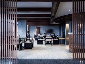 A modern interior with a seating area, a flat-screen TV, and a stone wall. - Grand Millennium Shanghai Hongqiao (Shanghai)
