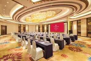 A conference room with long tables, chairs, and a large screen. - Grand Millennium Shanghai Hongqiao (Shanghai)