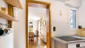 Een keuken met een fornuis, oven en een eethoek met stoelen en een tafel.