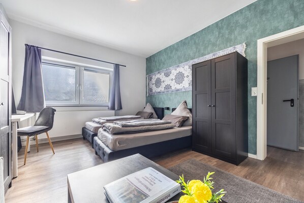 Ein modernes Schlafzimmer mit Bett, Schreibtisch, Stuhl und Kleiderschrank.