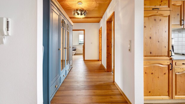 A hallway with wooden flooring, a blue cabinet, and wooden cabinets. - Apartment 'Wohnung Auf Dem Dorf' with Wi-Fi (Zarpen)