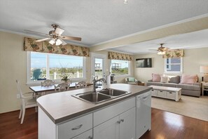 Relax in this inviting living area with a kitchen island, dining table, and comfortable sofa.