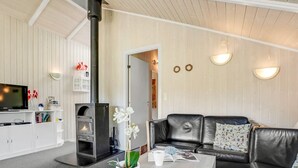 A cozy living room with a fireplace, a sofa, a coffee table, and a TV. - "Guja" - 250m from the sea by Interhome (Faxe Ladeplads)