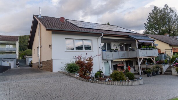 A two-story building with a balcony, solar panels, and a paved driveway. - Apartment 'Collenberger Ferienwohnung Schäfer' with Private Terrace, Garden & Wi-Fi (Collenberg)