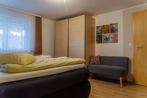 Une chambre à coucher avec un lit, un canapé, une armoire et une porte.