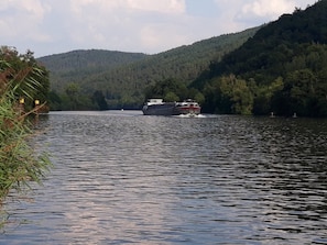 Une rivière avec un bateau qui se dirige vers le spectateur.