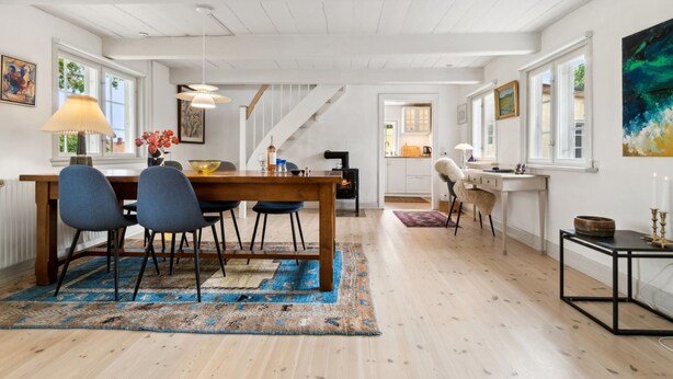 A spacious living area with a wooden dining table, blue chairs, and a large rug. - "Øde" - 100m from the sea by Interhome (Svaneke)