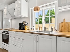 Kjøleskap, ovn, høy barnestol og kjøkkenutstyr