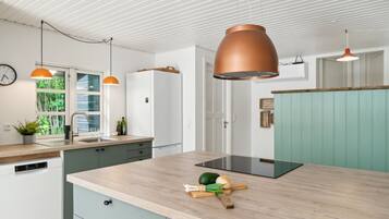 Une cuisine moderne dotée d’un îlot central, d’un évier et d’un réfrigérateur.