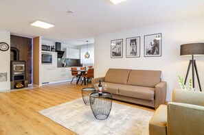 A modern living room with a sofa, two wireframe coffee tables, and a dining area with chairs. - FeWo-Time4you with Pool, Sauna, Terrace and Wi-Fi (Radolfzell am Bodensee)