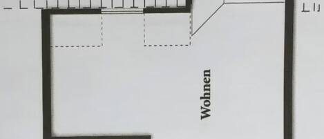 Un plan d’étage comprenant un espace de vie, une cuisine, une salle de bain et un balcon.