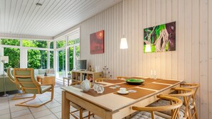 A dining area with a wooden table and chairs, a television, and artwork on the walls. - "Dagny" - 100m from the sea by Interhome (Knebel)