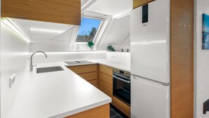 A modern kitchen with a skylight, white cabinetry, and a built-in oven. - "Ardan" - 450m from the sea by Interhome (Ebeltoft)