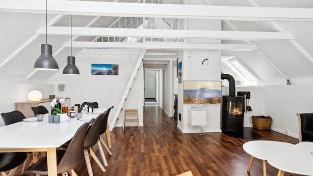A spacious loft with a high ceiling, a dining area with a long table and chairs, a fireplace, and a large window providing natural light. - "Ardan" - 450m from the sea by Interhome (Ebeltoft)
