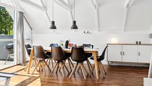 A modern kitchen with a dining area, featuring a wooden table, black chairs, and pendant lighting. - "Ardan" - 450m from the sea by Interhome (Ebeltoft)
