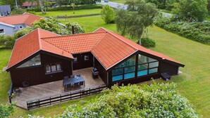 A modern house with a sloped roof, large windows, and a deck. - "Hermund" - 100m from the sea by Interhome (Ebeltoft)
