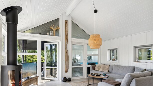 A modern living room with a fireplace, a sofa, and a dining area. - "Hermund" - 100m from the sea by Interhome (Ebeltoft)