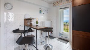 Una cocina con barra, un reloj y vistas a través de la puerta.